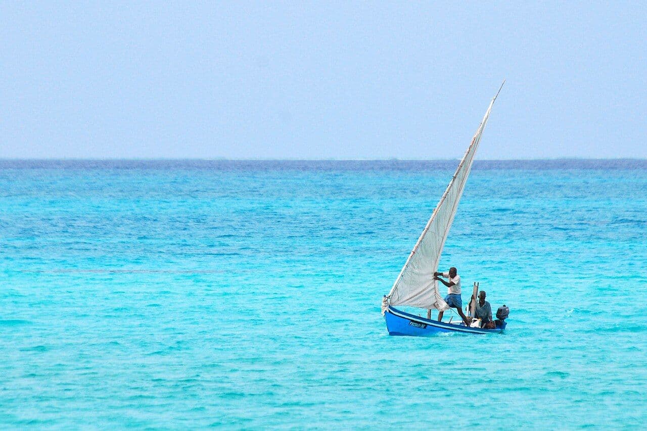 A small sailing boat on bright turquoise sea under a clear sky